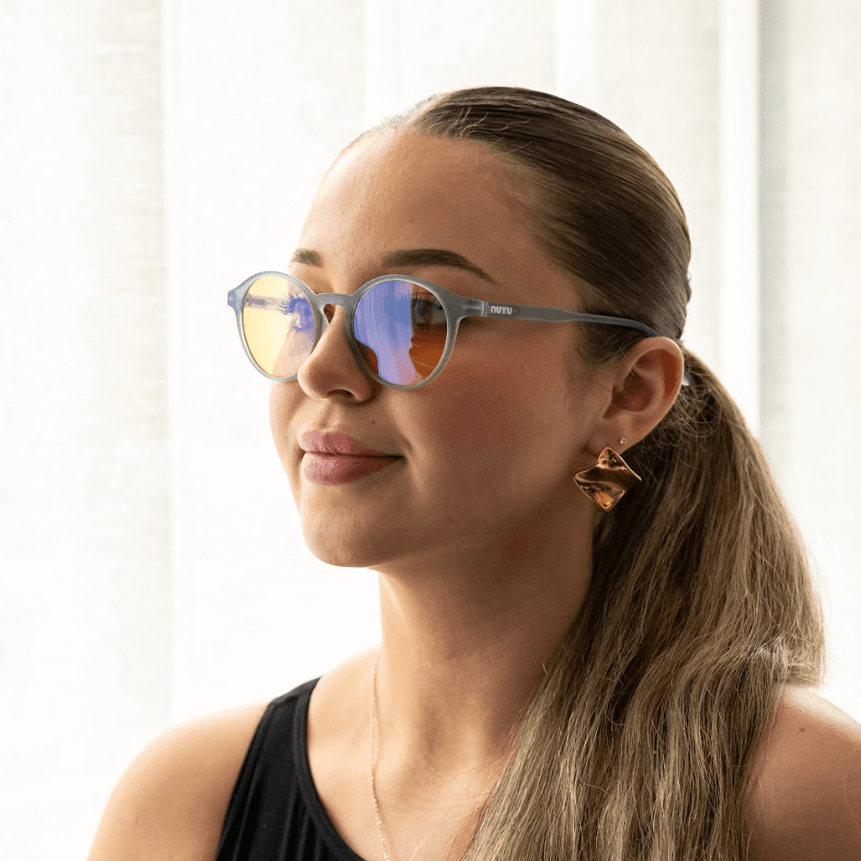 NUYU Afterlight blue light blocking glasses UK worn by woman with ponytail and gold earrings