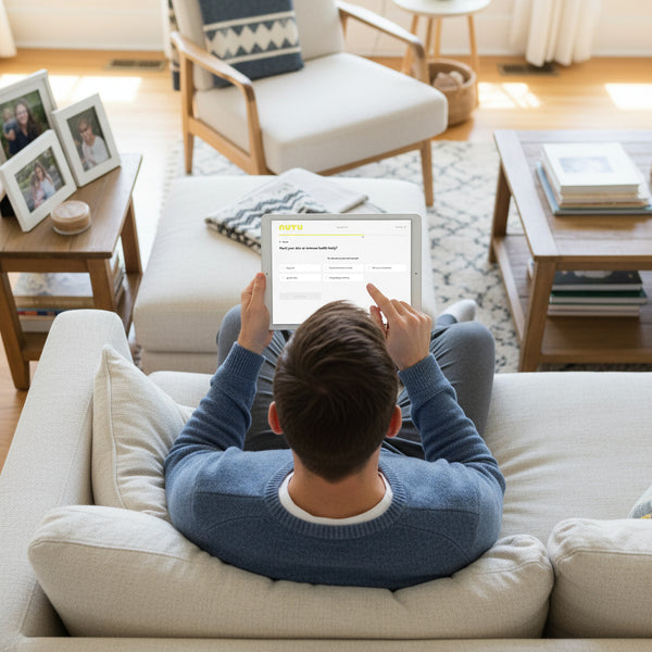Person using tablet for NUYU wellness supplement order from comfortable living room sofa