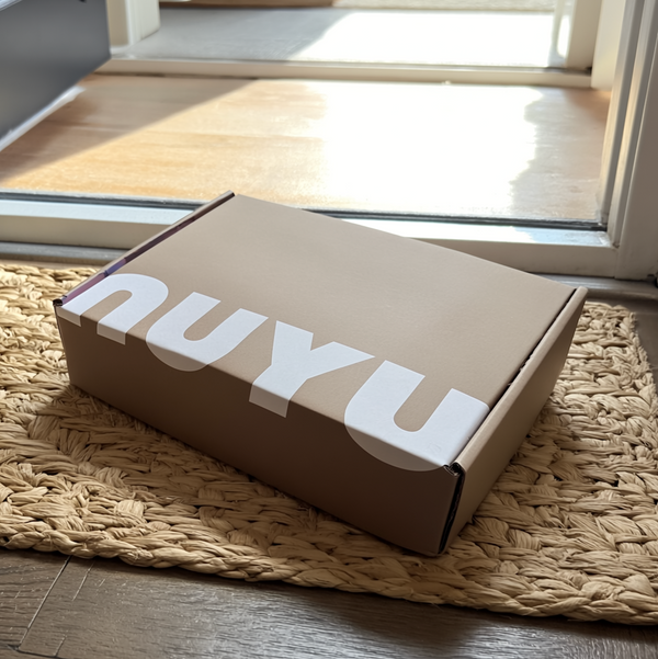 NUYU wellness brand subscription box delivered to doorstep on woven mat
