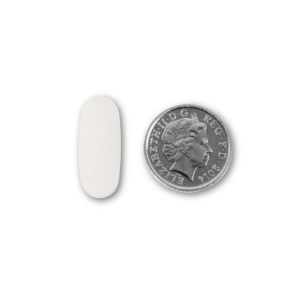 NUYU calcium tablet shown next to UK coin for size comparison of daily vitamins