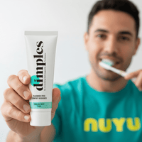 Dimples remineralising toothpaste tube held by man brushing teeth for enamel restoration and sensitivity relief