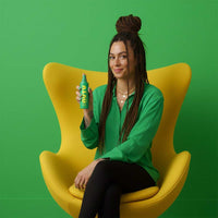 woman sitting on yellow chair holding NUYU Everyday Magnesium Spray bottle for magnesium boost