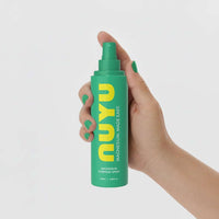 Hand holding NUYU Everyday Magnesium Spray bottle for fast-absorbing magnesium boost