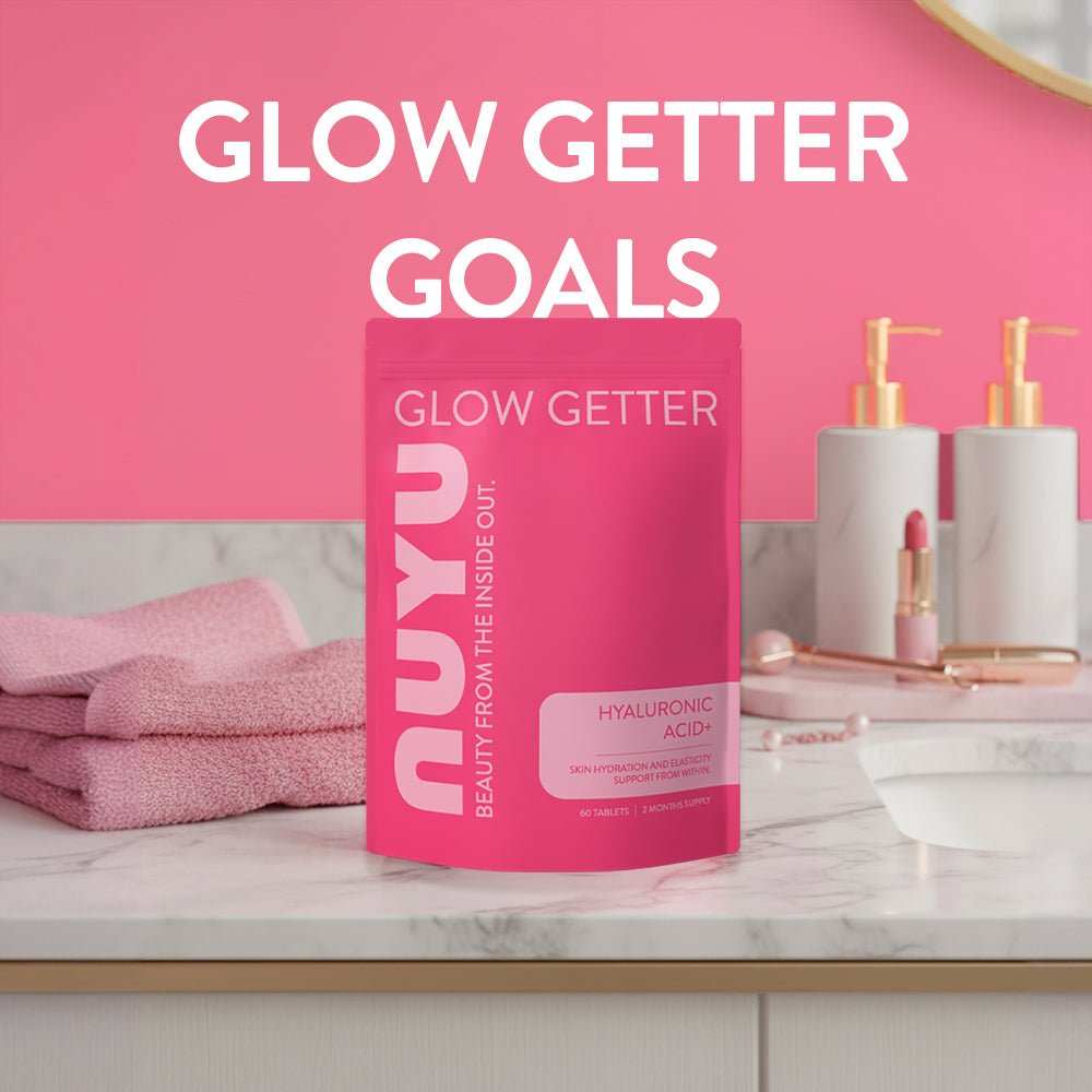NUYU Hyaluronic Acid+ wellness supplement UK in pink bathroom setting with towels and cosmetics