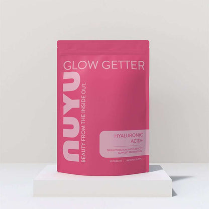 NUYU Hyaluronic Acid+ wellness supplement UK pink pouch on white geometric display stand