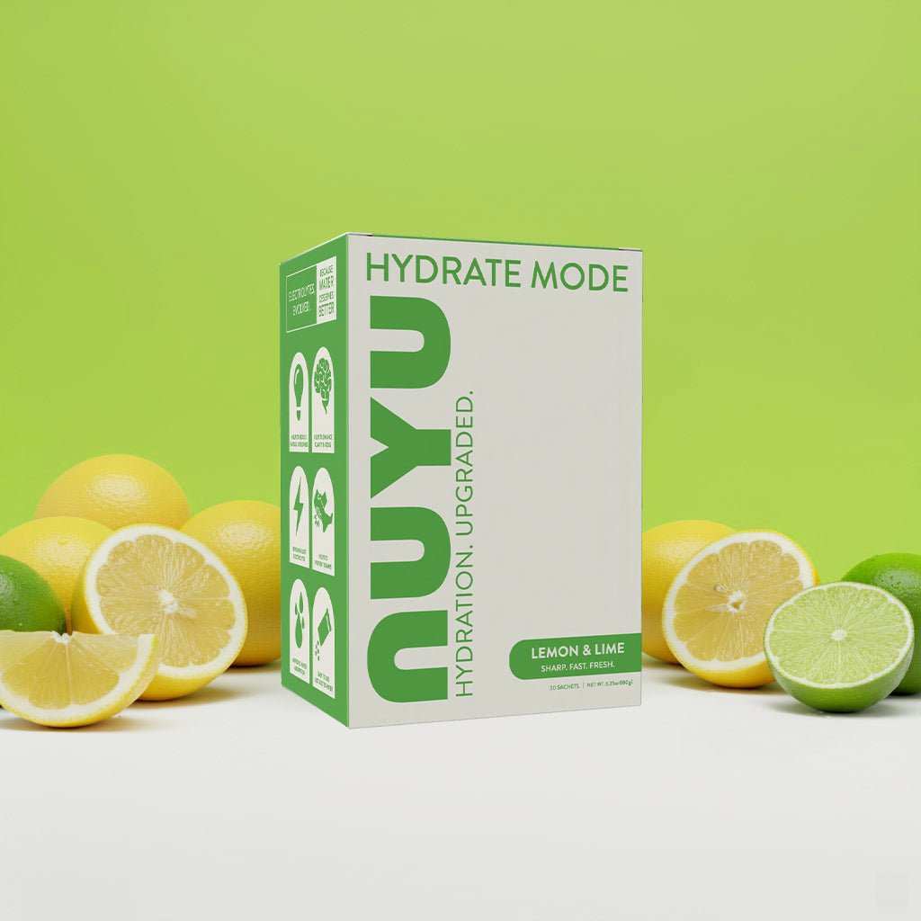 Hydrate Mode lemon and lime electrolyte powder box with fresh citrus fruits on green background
