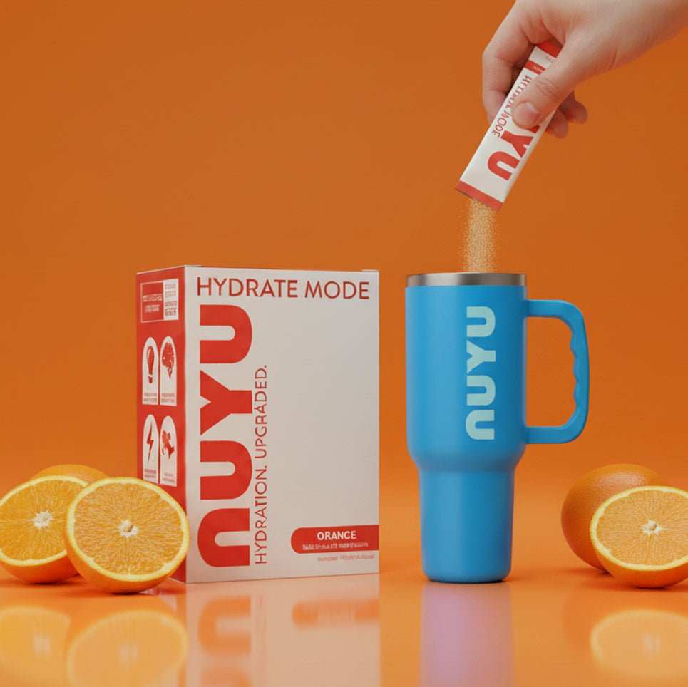 Hydrate Mode Orange sachet being poured into blue Nuyu cup with fresh oranges and product box on orange background for airborne vitamin c hydration boost