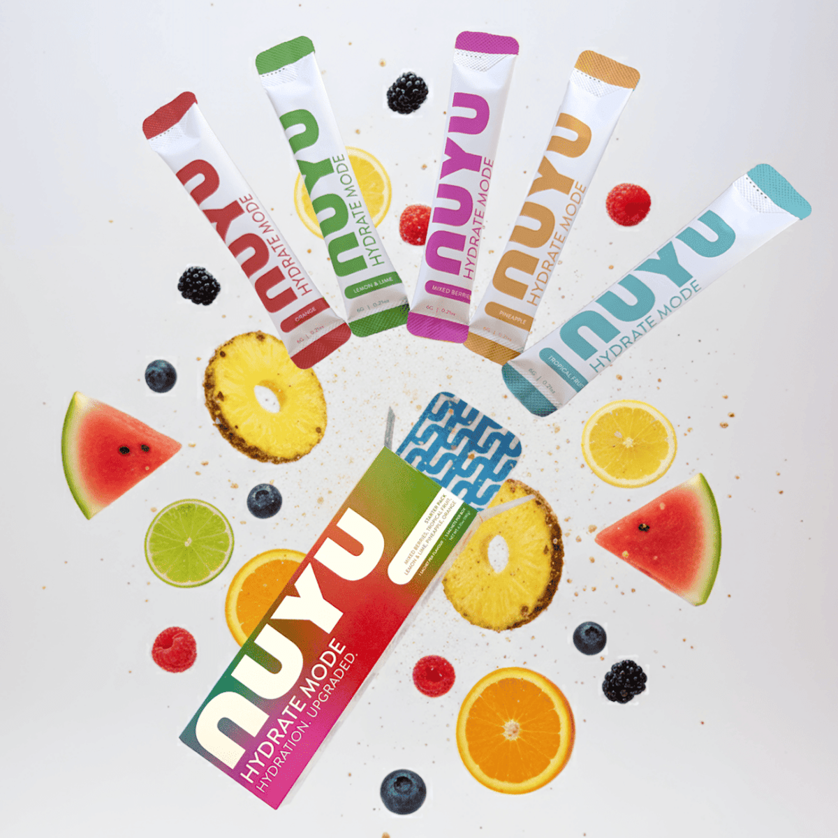 NUYU hydration electrolyte sachets UK arranged in colorful fan with fresh fruit slices