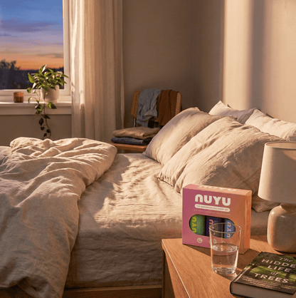 NUYU magnesium supplement UK discovery set on bedside table in cozy bedroom setting
