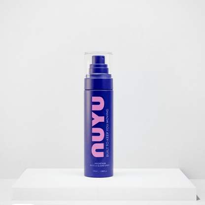 NUYU magnesium muscle recovery spray UK in purple bottle with pump dispenser on white surface