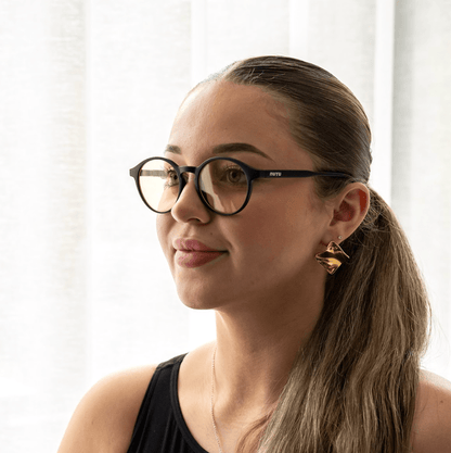 NUYU Afterlight blue light blocking glasses UK worn by woman with ponytail and gold earrings