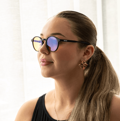 NUYU Afterlight blue light blocking glasses UK worn by woman with ponytail and gold earrings