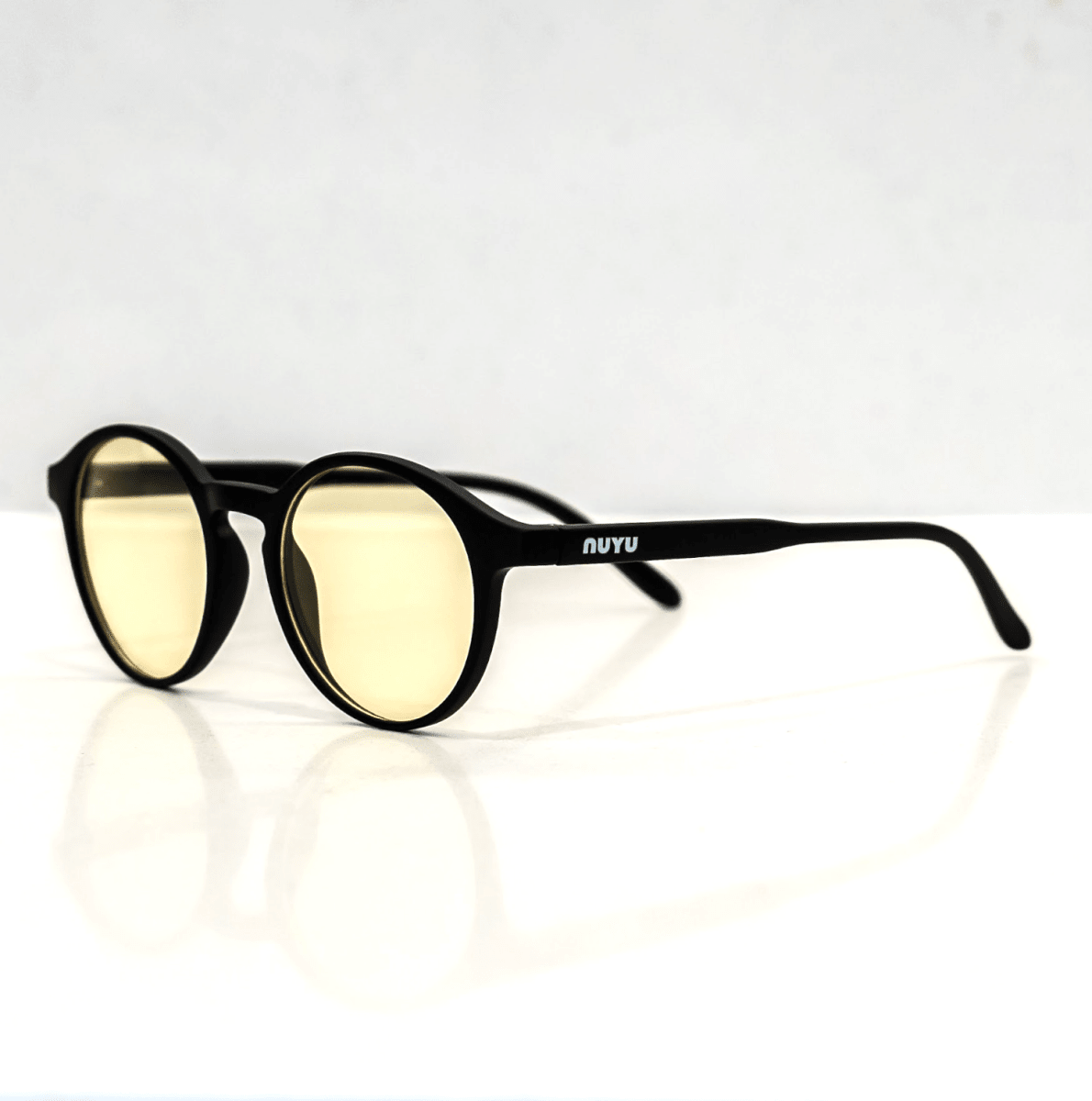 NUYU Afterlight blue light blocking glasses UK with yellow tinted lenses on white surface