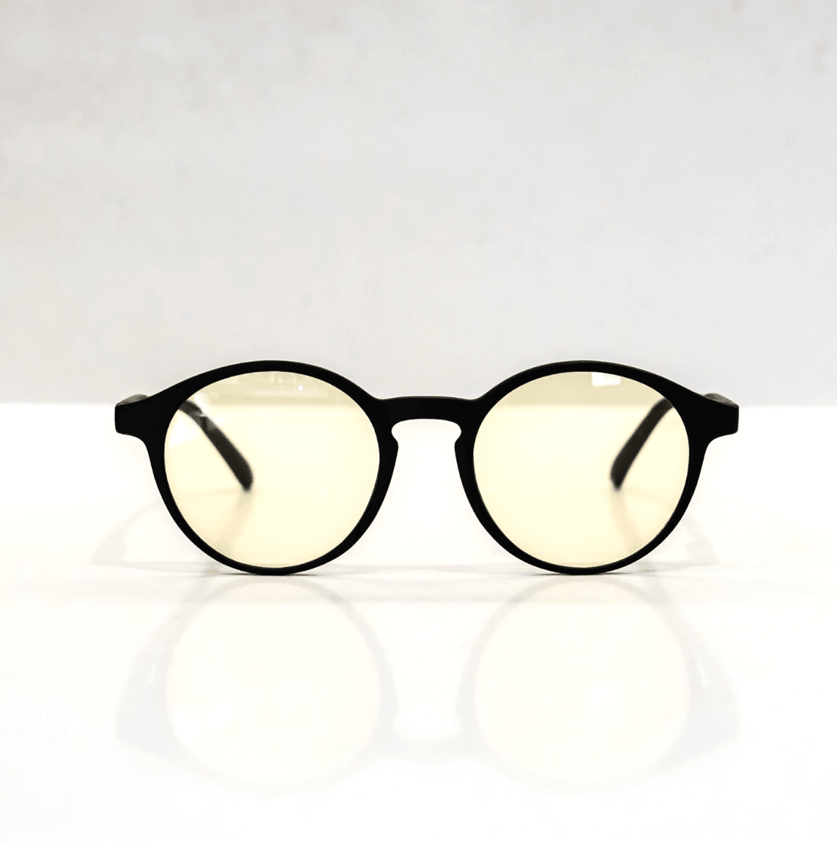 NUYU Afterlight blue light blocking glasses UK with black frames and yellow lenses on white surface