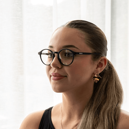 NUYU Afterlight blue light blocking glasses UK worn by woman with ponytail and gold earrings