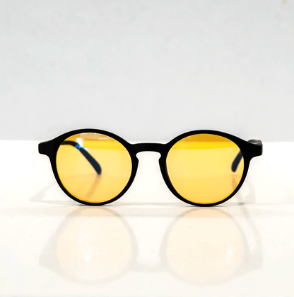 NUYU Afterlight blue light blocking glasses UK with yellow lenses and black frames on white surface