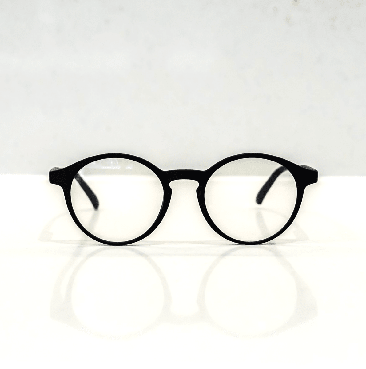 NUYU Afterlight blue light blocking glasses UK - black round frames on white surface