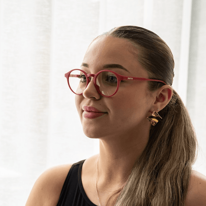 NUYU Afterlight blue light blocking glasses UK worn by woman with ponytail and gold earrings