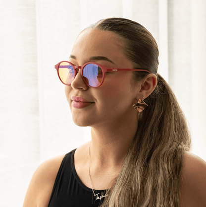 NUYU Afterlight blue light blocking glasses UK worn by woman with ponytail and gold earrings