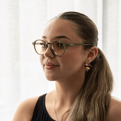 NUYU Afterlight blue light blocking glasses UK worn by woman with ponytail and gold earrings