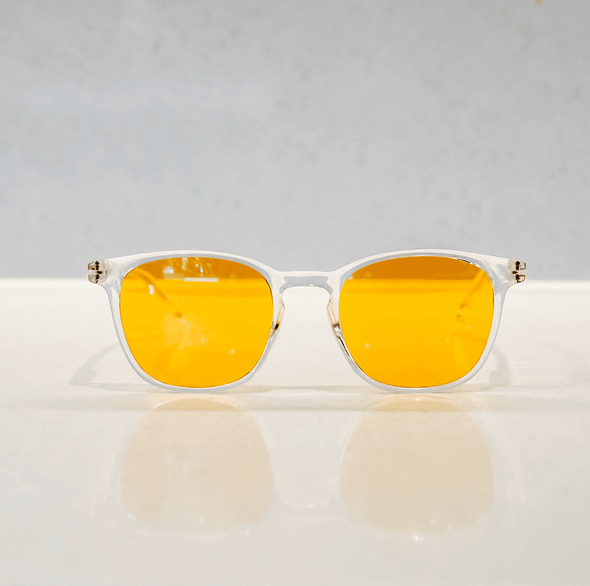 NUYU Afterlight blue light blocking glasses UK with clear frames and amber lenses on white surface