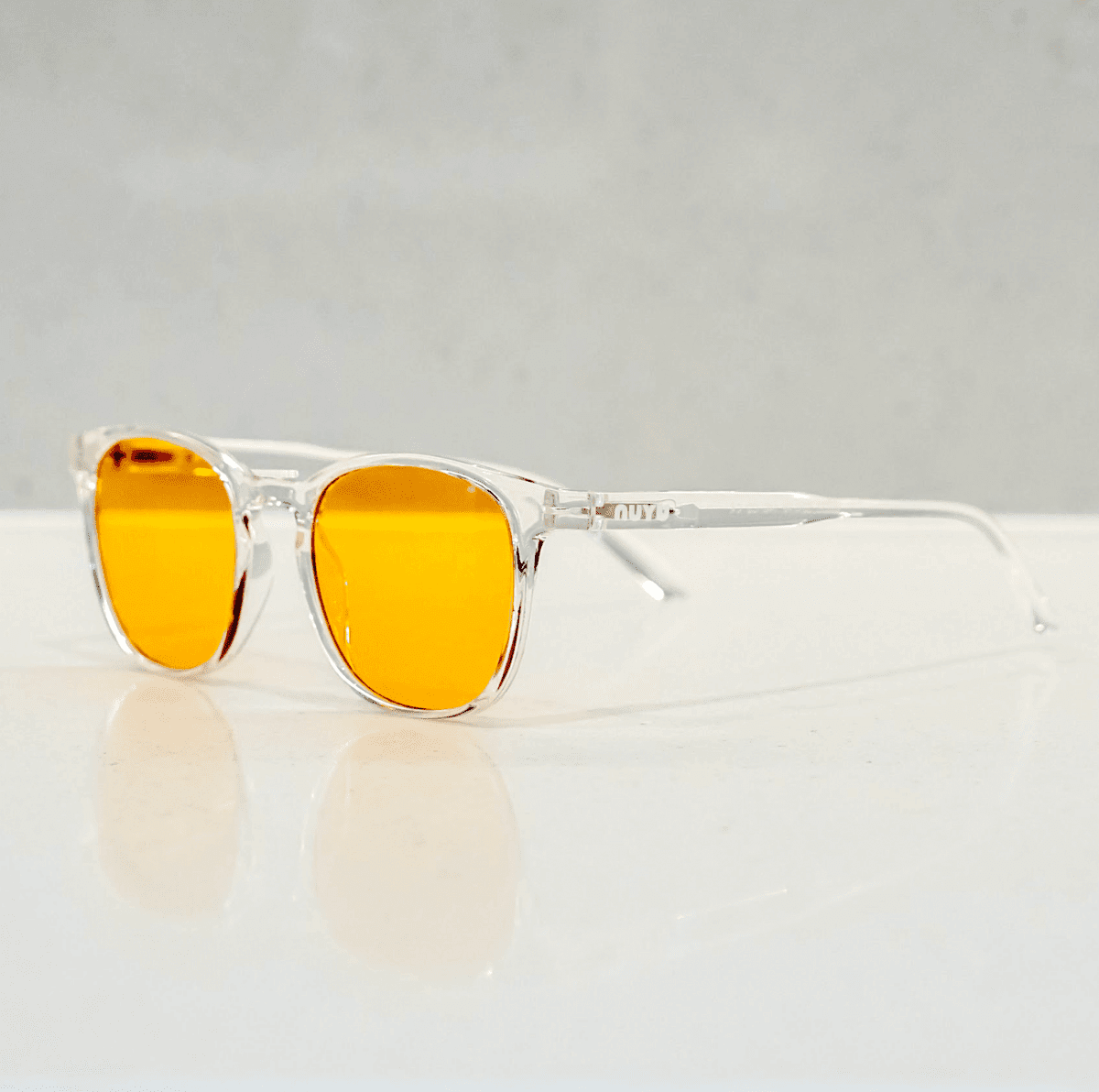 NUYU Afterlight blue light blocking glasses UK with clear frames and orange lenses on white surface