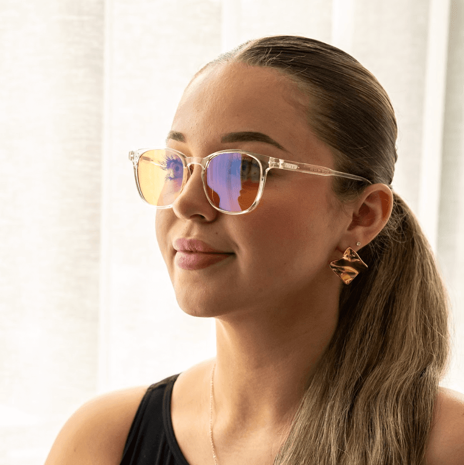 NUYU Afterlight blue light blocking glasses UK worn by woman with clear frames and reflective lenses