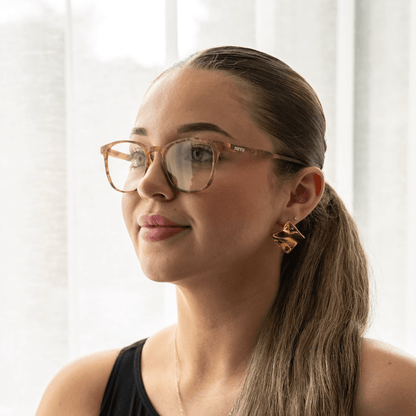 NUYU Afterlight blue light blocking glasses UK worn by woman with ponytail and earrings