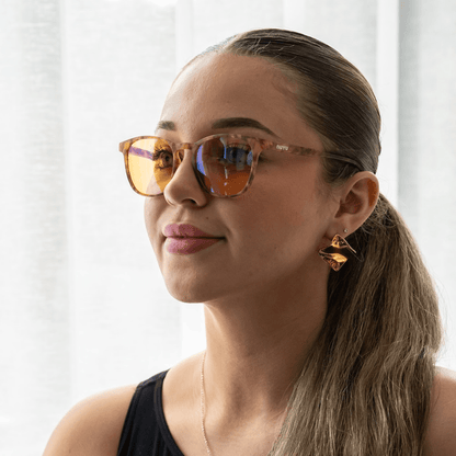 NUYU Afterlight blue light blocking glasses UK worn by woman with geometric earrings