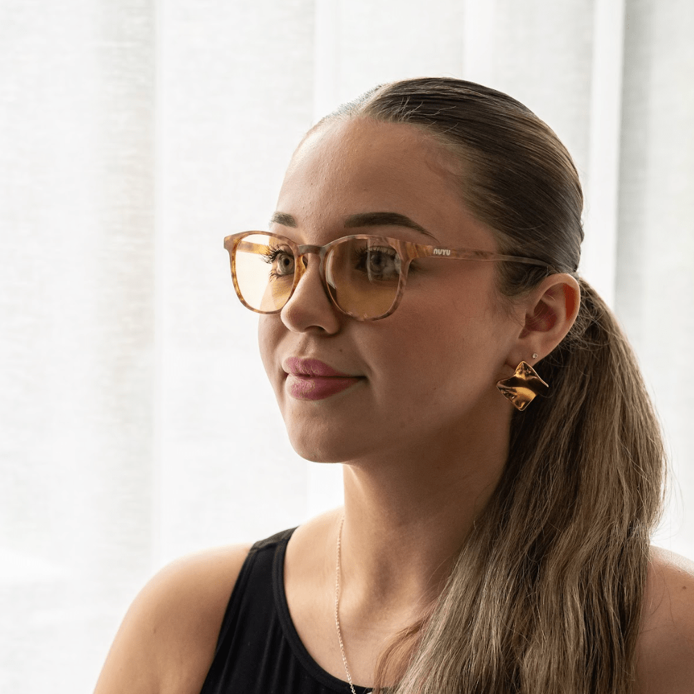 NUYU Afterlight blue light blocking glasses UK worn by woman with ponytail indoors