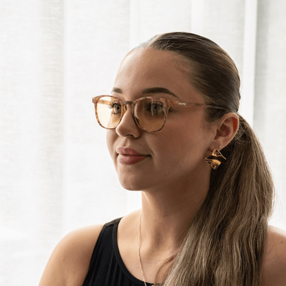 NUYU Afterlight blue light blocking glasses UK worn by woman with ponytail indoors