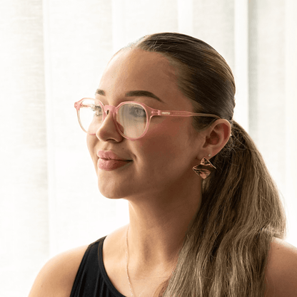 NUYU Afterlight blue light blocking glasses UK worn by woman with pink frames