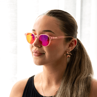 NUYU Afterlight blue light blocking glasses UK worn by woman with pink frames and colorful lenses