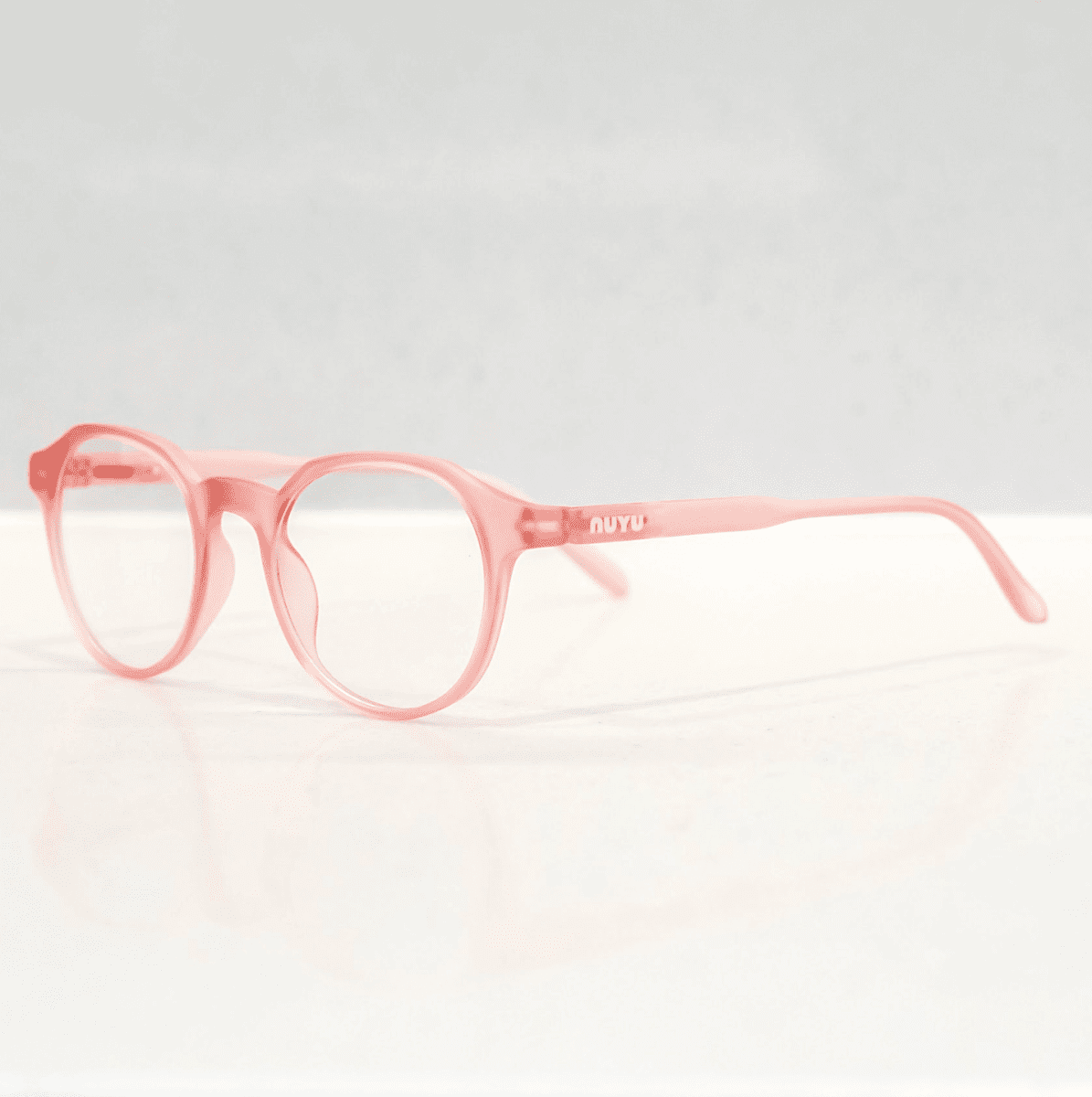 NUYU Afterlight blue light blocking glasses UK in translucent pink frames on white background