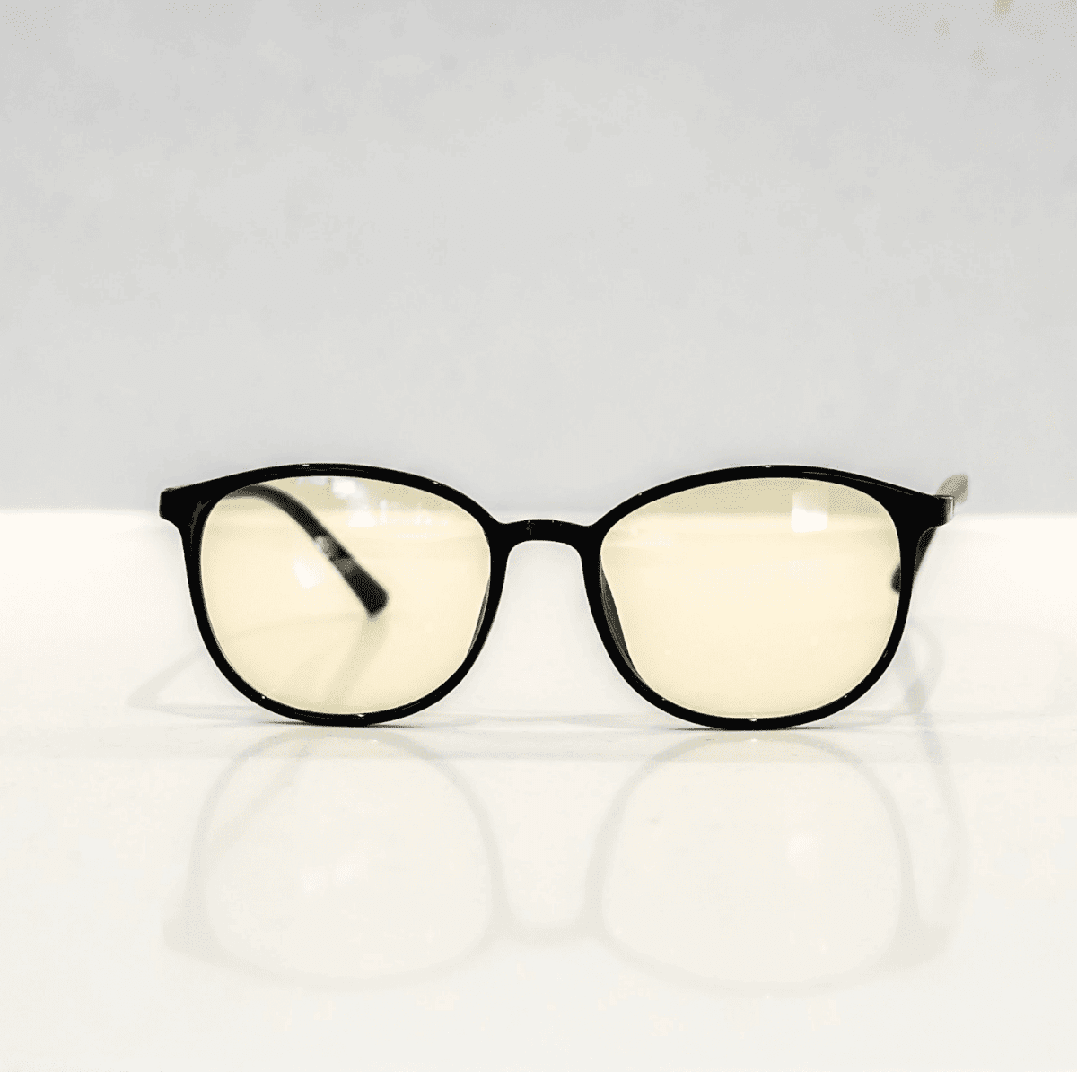 NUYU Afterlight blue light blocking glasses UK with yellow-tinted lenses on white surface