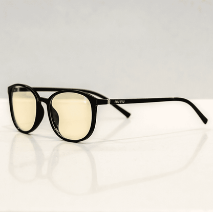 NUYU Afterlight blue light blocking glasses UK with black frames and yellow lenses on white surface