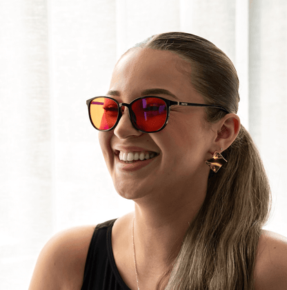 NUYU Afterlight blue light blocking glasses UK worn by smiling woman with ponytail