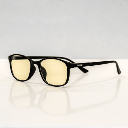 NUYU Afterlight blue light blocking glasses UK with yellow-tinted lenses on white surface