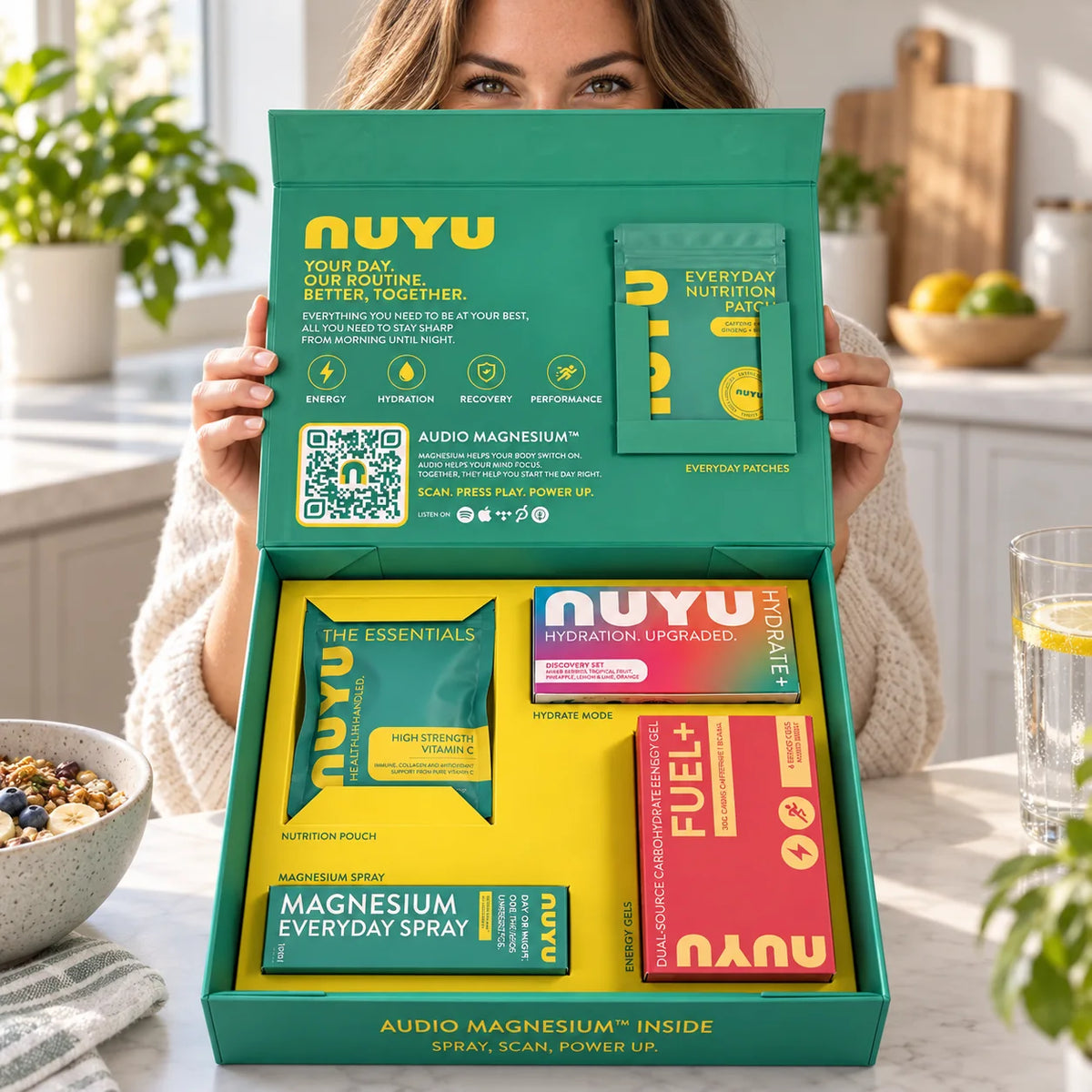 Holding the open NUYU Everyday Edition box in a kitchen
