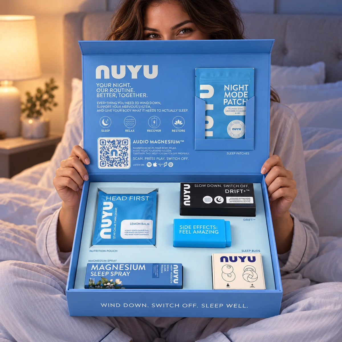 Holding the open NUYU Sleep Edition box in bed