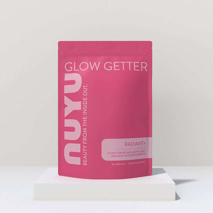 NUYU RADIANT+ biotin supplement UK in pink pouch packaging on white geometric display