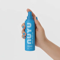 Hand holding blue NUYU Sleep Magnesium Spray bottle with Night Mode On for restful sleep and relaxation