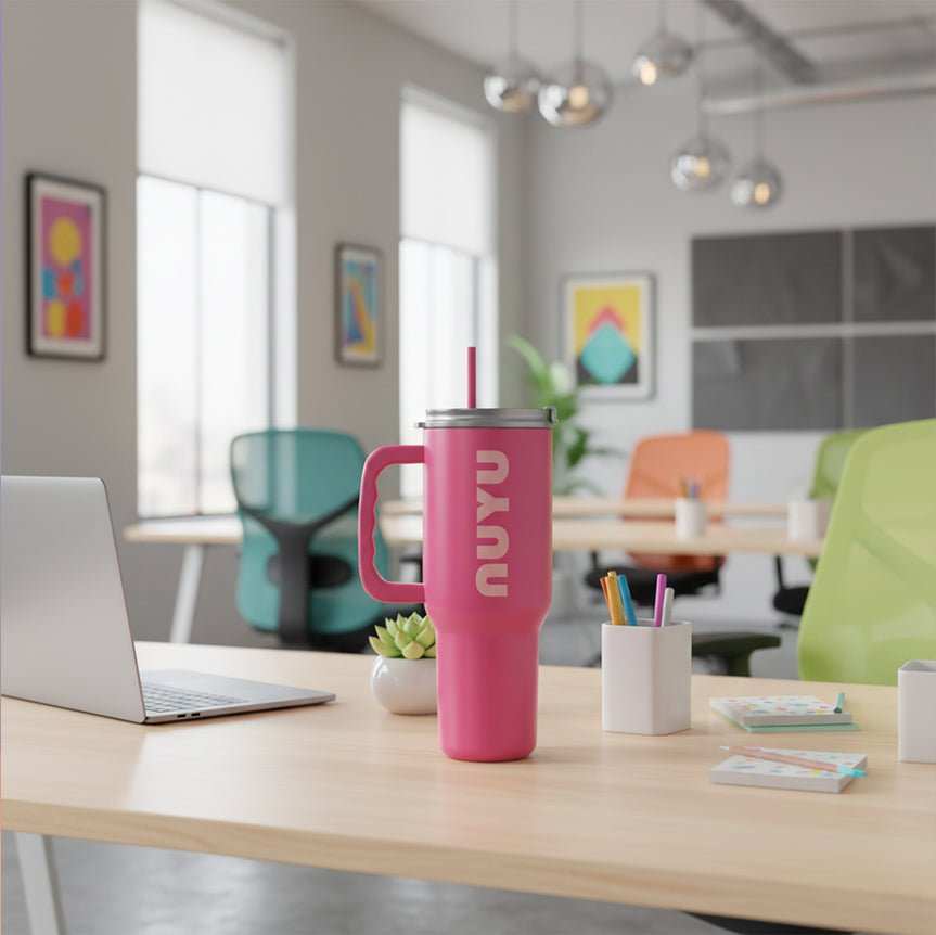 NUYU pink insulated tumbler on modern office desk with laptop and colorful workspace