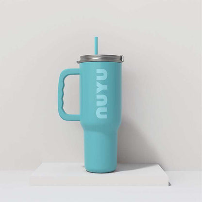 NUYU turquoise insulated tumbler UK with handle and straw on white surface